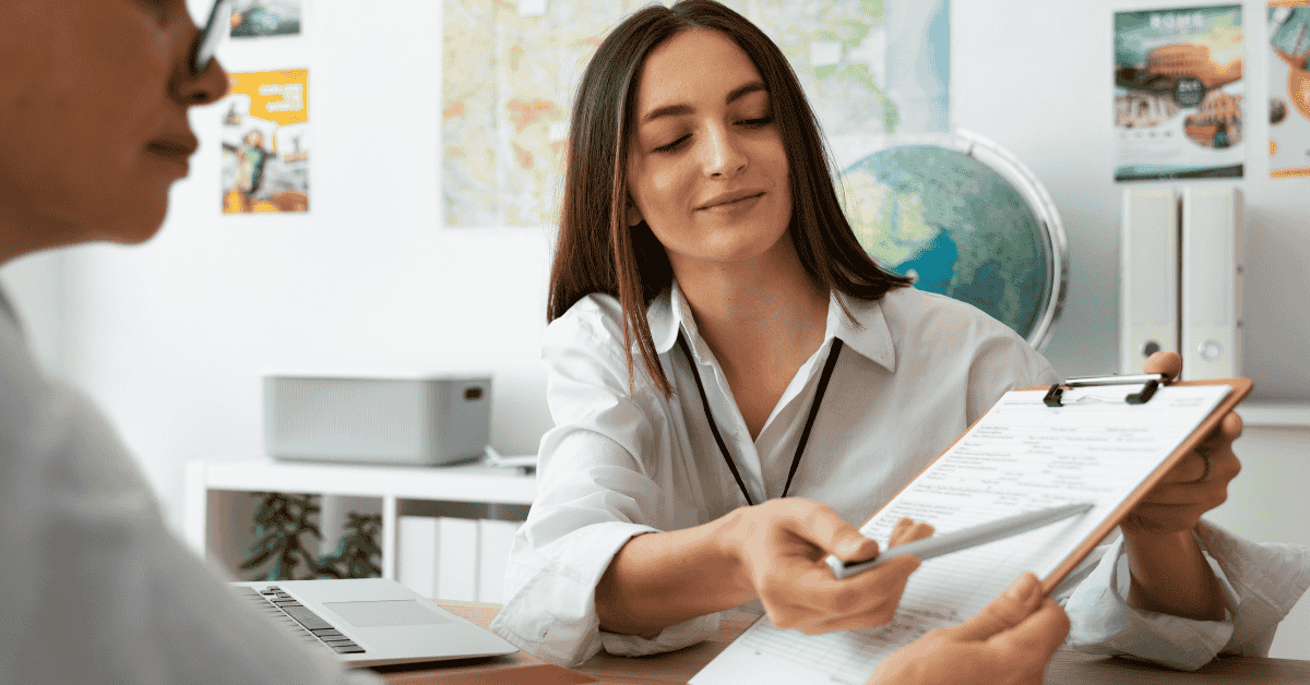 Atendente entregando um formulário a uma cliente em um escritório, em um processo de solicitação de empréstimo.